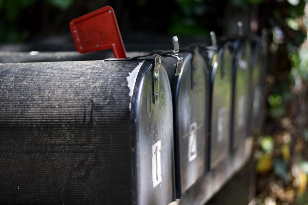 Rząd tradycyjnych skrzynek pocztowych leżących koło siebie.