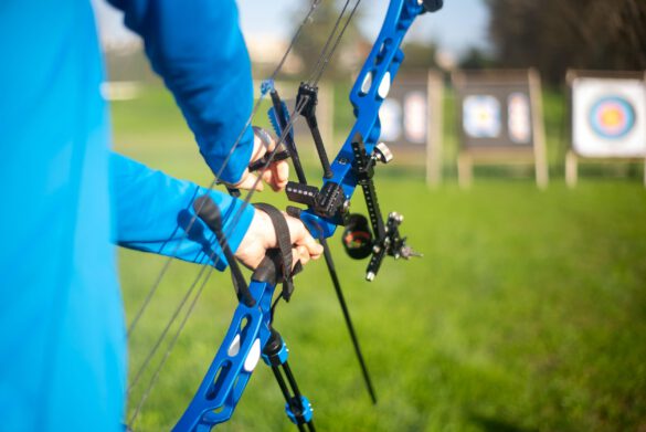 osoba trzymająca łuk sportowy